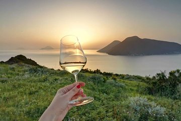 Wine tasting in vineyard at the sunset in Lipari island